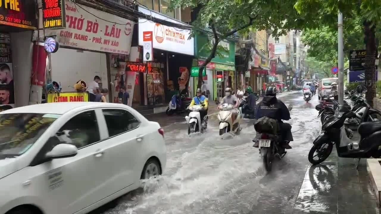 Phương tiện di chuyển qua đoạn ngập trên phố Nguyễn Huy Tưởng