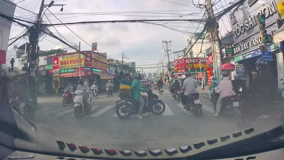 Người đi xe máy che chắn giúp người đi bộ qua đường