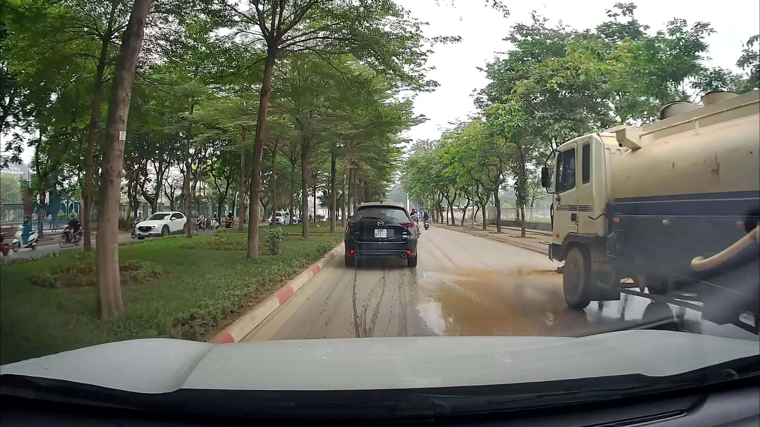 Xe bồn phun nước bùn đất ra đường phố Hà Nội