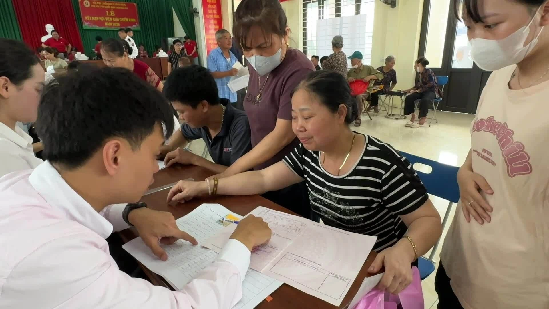 Người dân ôm bao tải, xách túi đi nhận tiền đền bù đất