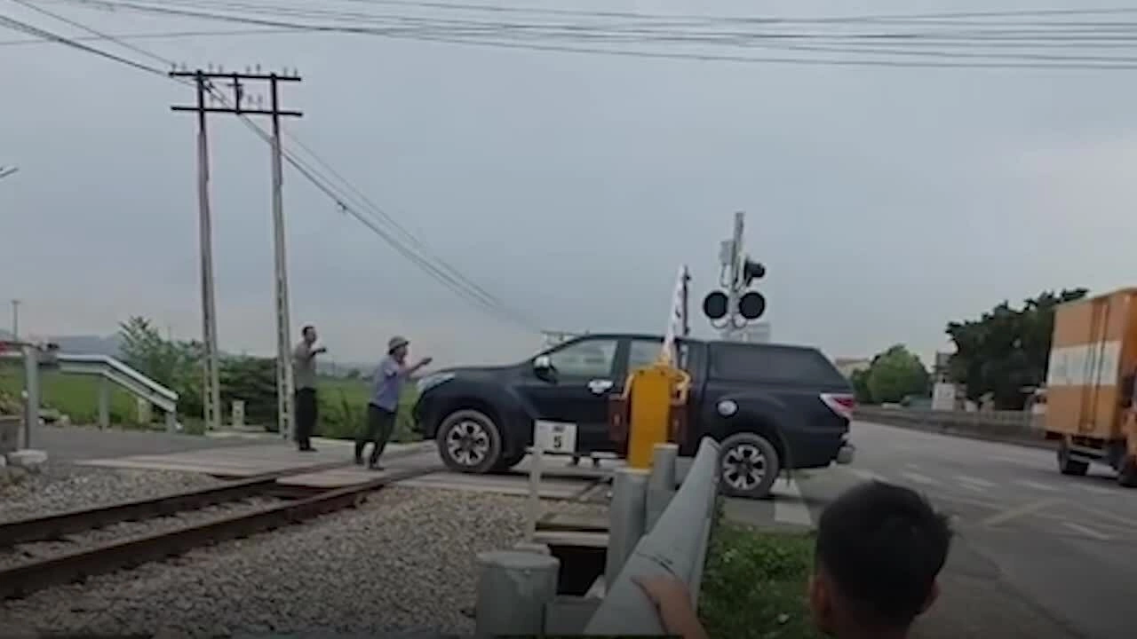 Nữ tài xế định lái ôtô vượt gác chắn khi tàu sắp qua